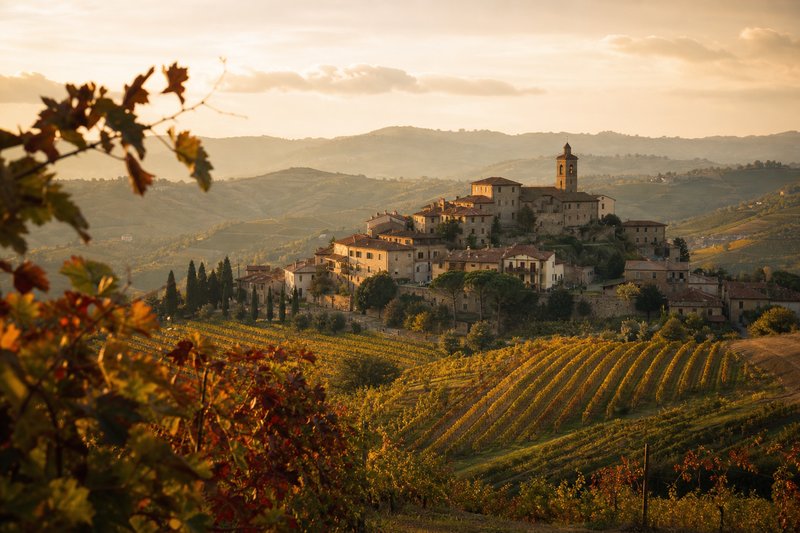 Borgo del vino tra le colline, con vigneti e architetture storiche al tramonto